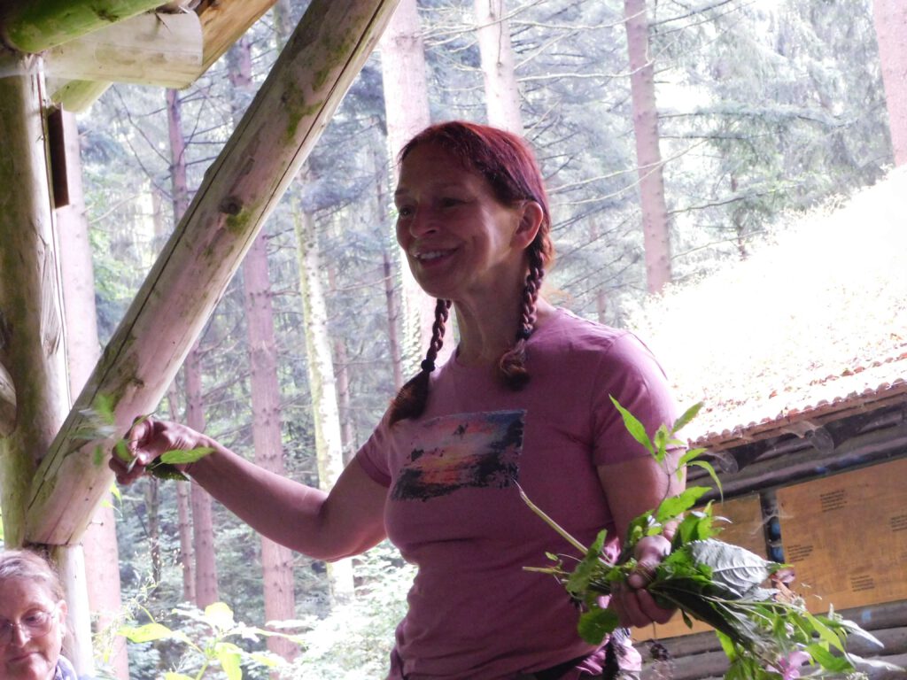 Aloisia Schönke zeigt beim Fastenwandern in der Pause Wildkräuter.